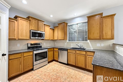 A kitchen with wooden cabinets and a black countertop.