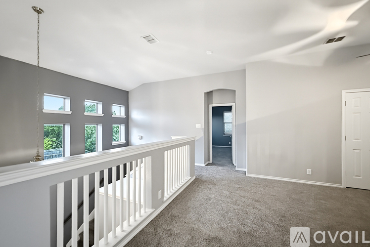 A spacious room with a balcony and a door leading to another room.