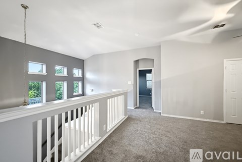 A spacious room with a balcony and a door leading to another room.