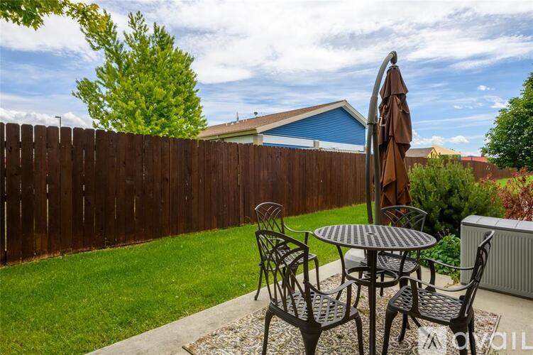 A patio with a table, chairs, and an umbrella.