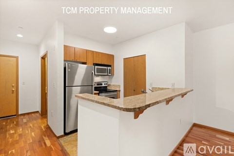 A kitchen with a refrigerator, microwave, oven, and sink is available for rent.