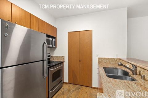 A kitchen with a stainless steel refrigerator, microwave, oven, and sink.