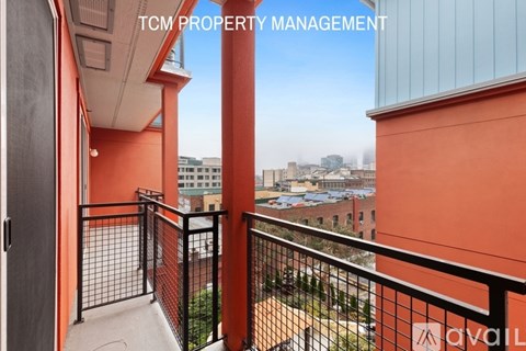 A balcony with a view of the cityscape and buildings.