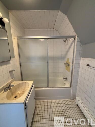 A bathroom with a sink, mirror, and shower.