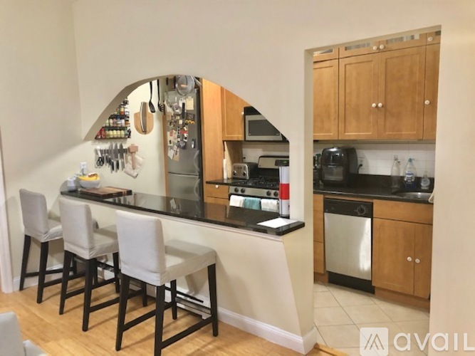A kitchen with a bar area and chairs.