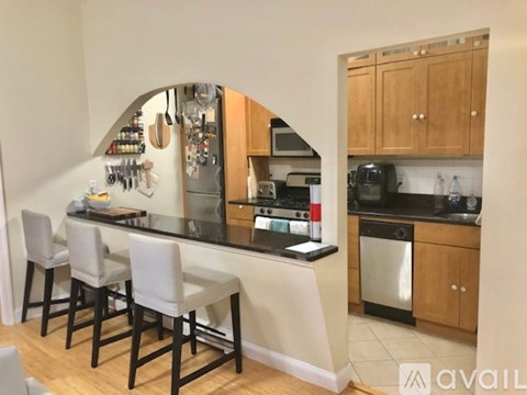 A kitchen with a bar area and chairs.