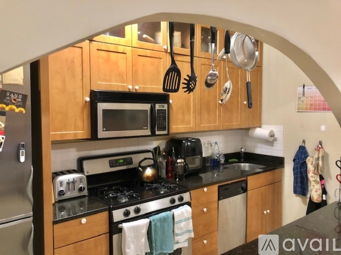 A kitchen with wooden cabinets and a black countertop.