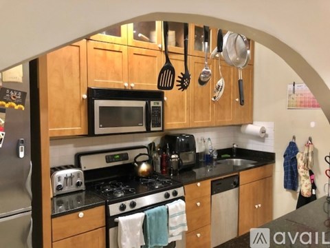 A kitchen with wooden cabinets and a black countertop.