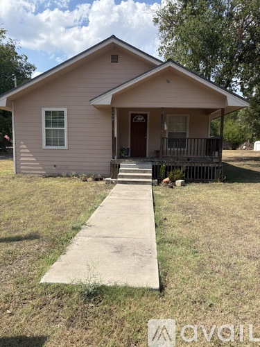 A small house with a brown door and a porch.