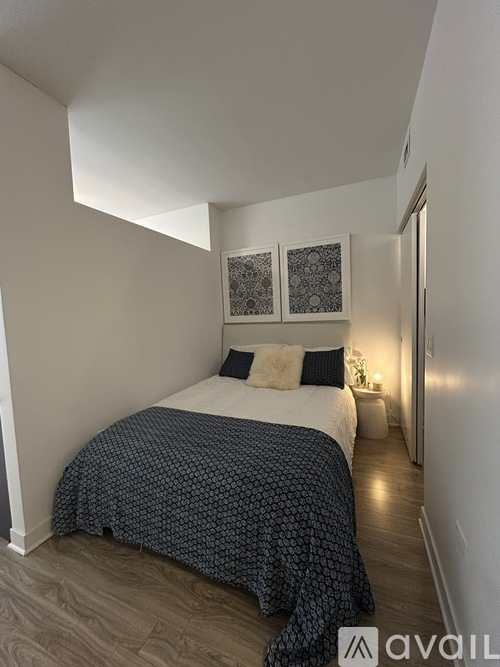 A bedroom with a bed covered in a blue and white patterned bedspread.