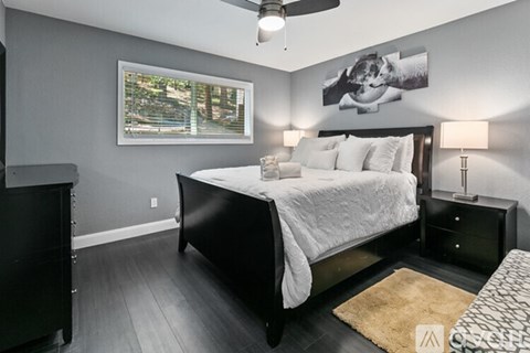 A bedroom with a large bed and a ceiling fan.
