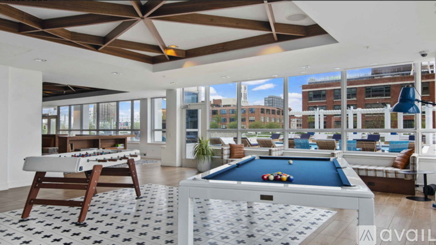 A billiard table is in the middle of a room with a pool table and a view of the city.