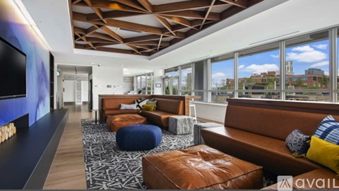 A living room with a brown leather couch and a patterned rug.