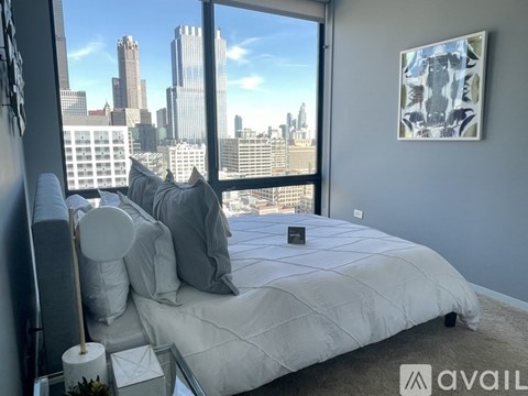 A bedroom with a large bed and a view of the city skyline.