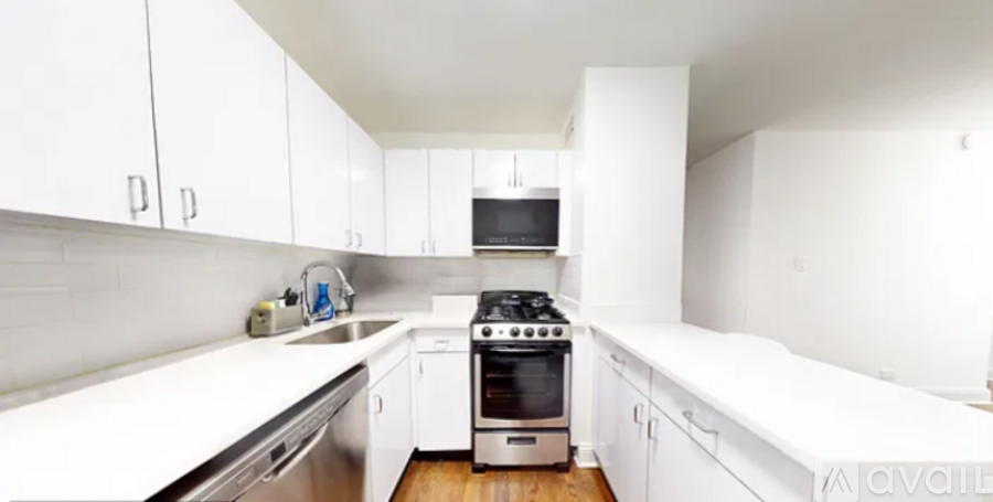 A kitchen with white cabinets and a stove top oven.