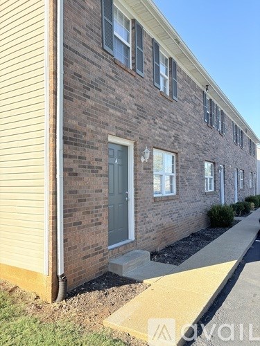A brick building with a grey door and windows.