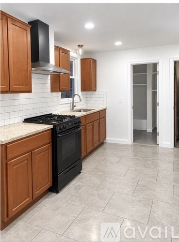 A kitchen with wooden cabinets and a black stove top oven.