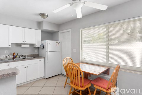 A kitchen with a table and chairs.