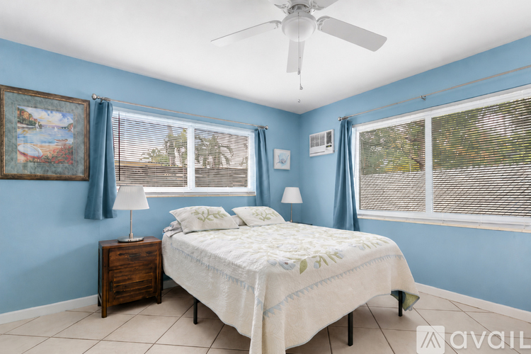 A bedroom with a bed, nightstand, and a ceiling fan.