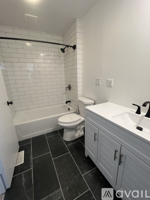 A white toilet sits next to a bathtub in a bathroom.