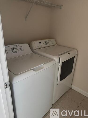 Two white front loading washing machines in a small room.
