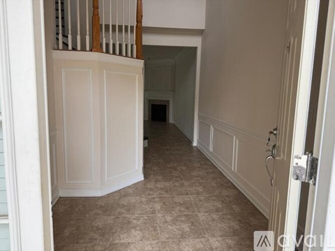 A hallway with a tiled floor and white walls.