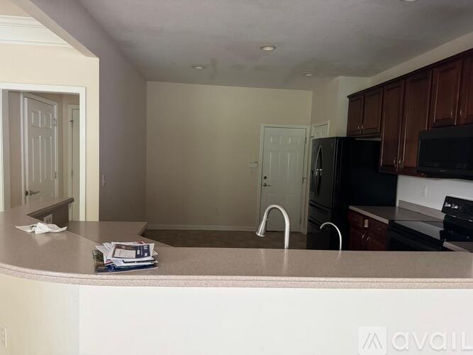 A kitchen with a white counter top and black appliances.