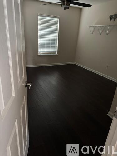 A room with a white door and a window with blinds.