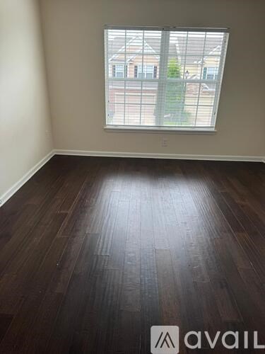 A room with a window and wooden flooring.