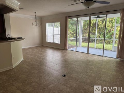 A living room with a ceiling fan and sliding glass doors.