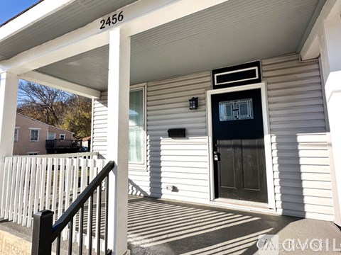 A house numbered 2456 with a black door and a small window above it.