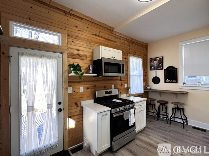 A kitchen with wooden walls and a white stove top oven.