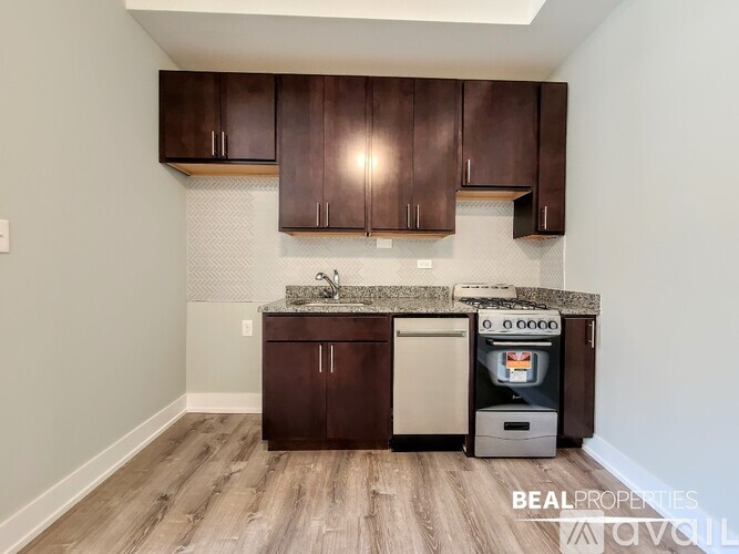 A kitchen with brown cabinets and a white wall.