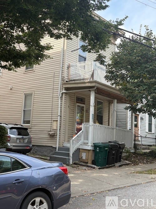 A blue car is parked in front of a house.