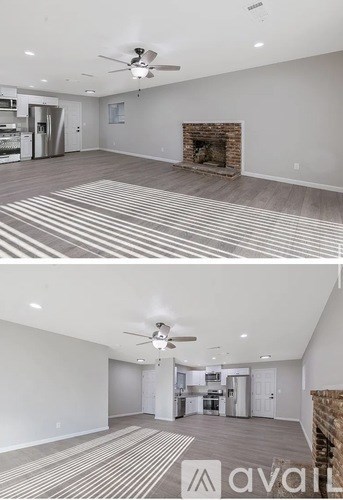 A living room with a fireplace and a ceiling fan.