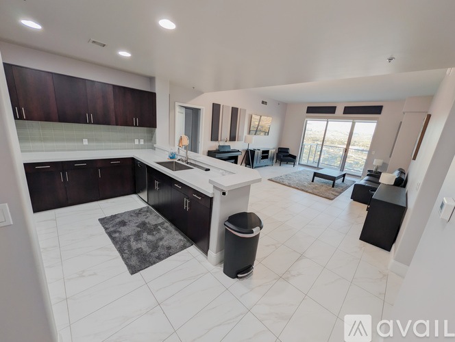 A spacious kitchen with dark brown cabinets and a white countertop.