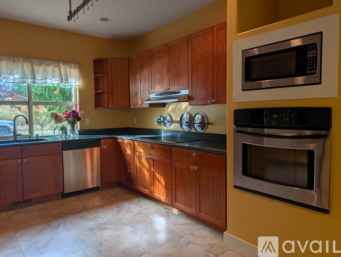 A kitchen with wooden cabinets and a black oven.