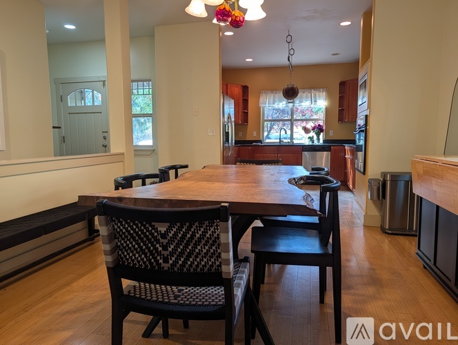 A dining room with a wooden table and chairs.
