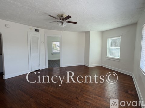 A room with a ceiling fan and wooden floors.