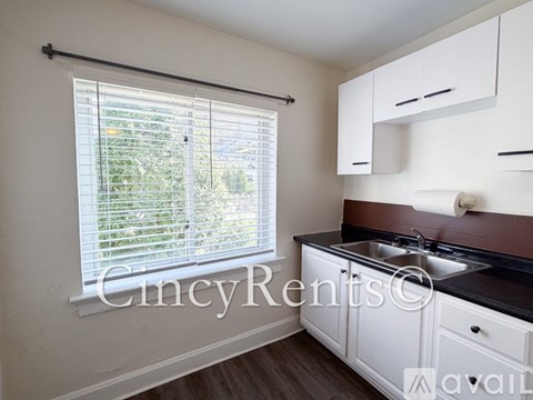 A kitchen with white cabinets and a black countertop.