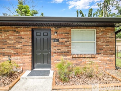 A small brick house with a black door and a window.