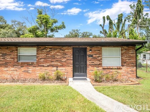 A brick house with a black door and windows.