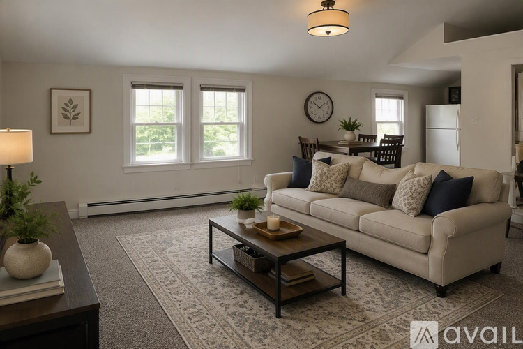 A living room with a beige couch, a coffee table, and a lamp.
