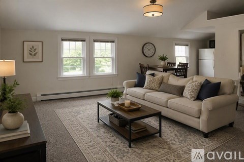A living room with a beige couch, a coffee table, and a lamp.