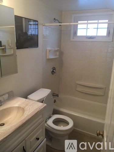 A bathroom with a toilet, sink, and mirror.