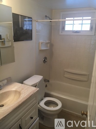 A bathroom with a toilet, sink, and mirror.