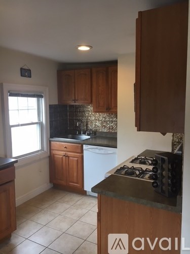 A kitchen with wooden cabinets and a white dishwasher.