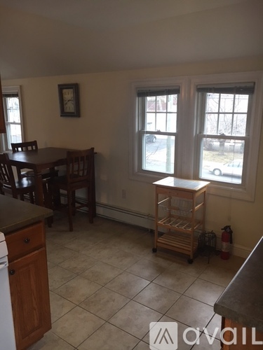 A kitchen with a table and chairs.