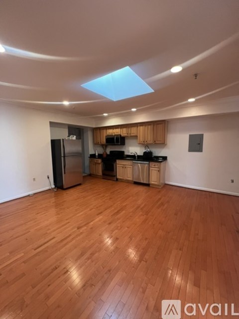 A kitchen with wooden floors and a skylight.