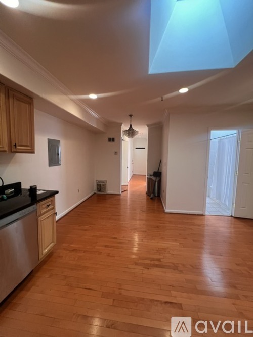 A kitchen with wooden floors and a skylight.